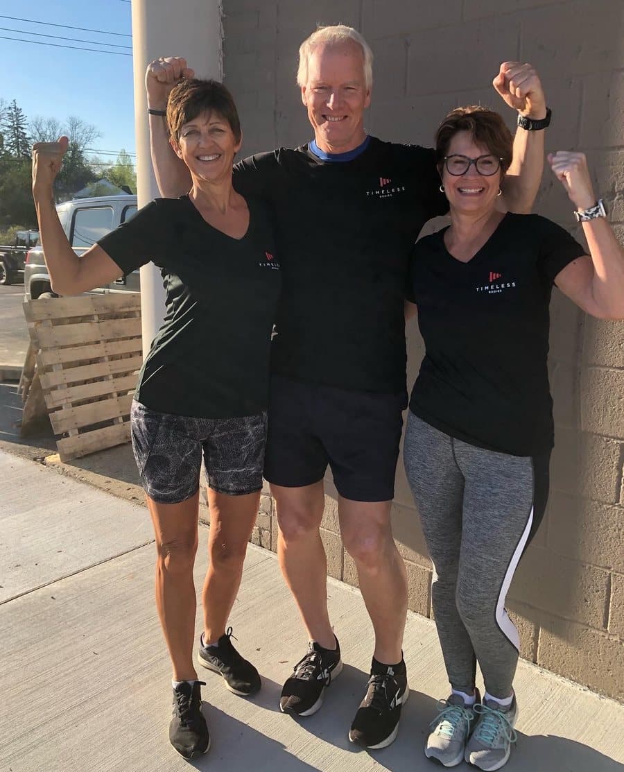 Coach Bruce with two smiling clients after a training session